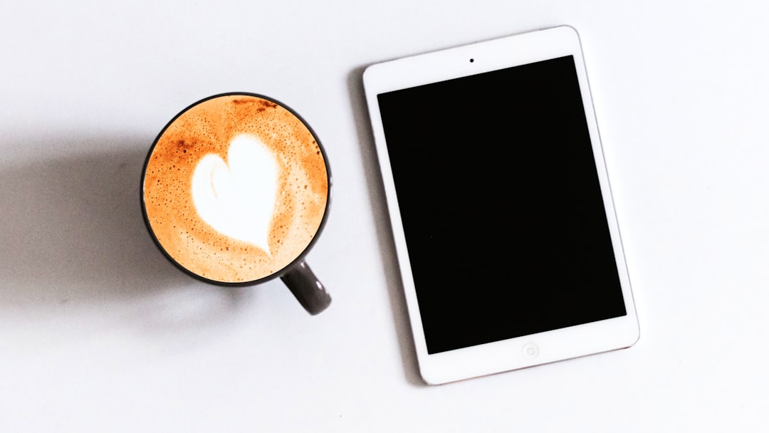 コーヒーのそばに置かれたタブレット